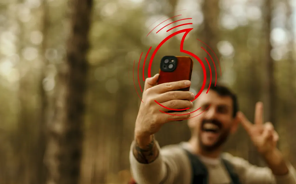Muž pořizující selfie v lese s dítětem v batohu na zádech